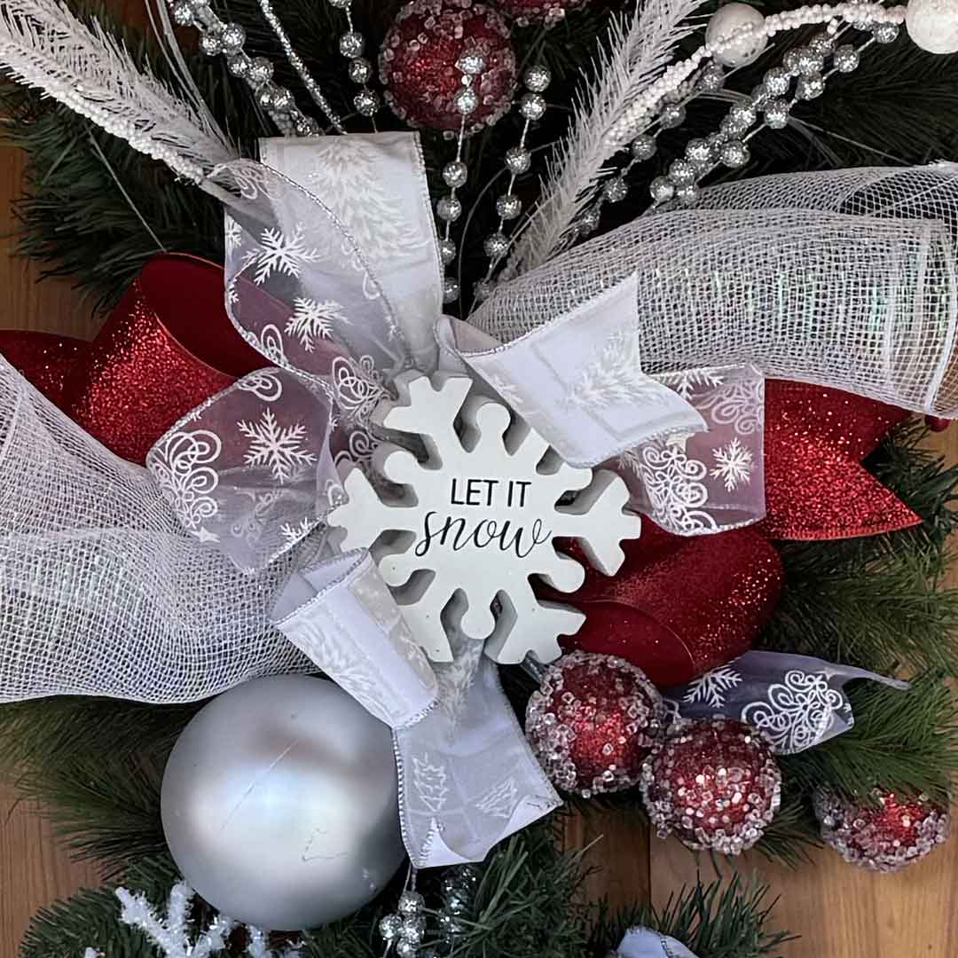 Close-up of Holiday swag with evergreen, ribbon, and a ‘Let It Snow’ sign at Broadwater Hot Springs in Helena, Montana.